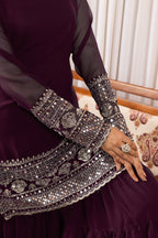 Close-up of a dark purple dress with intricate silver embroidery on a patterned chair.