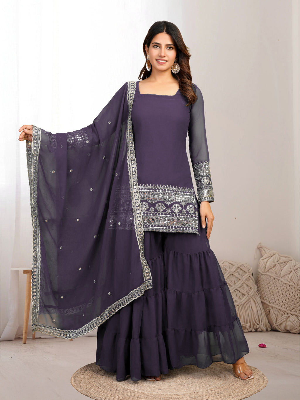 Woman wearing a purple traditional outfit with a matching dupatta on a neutral background