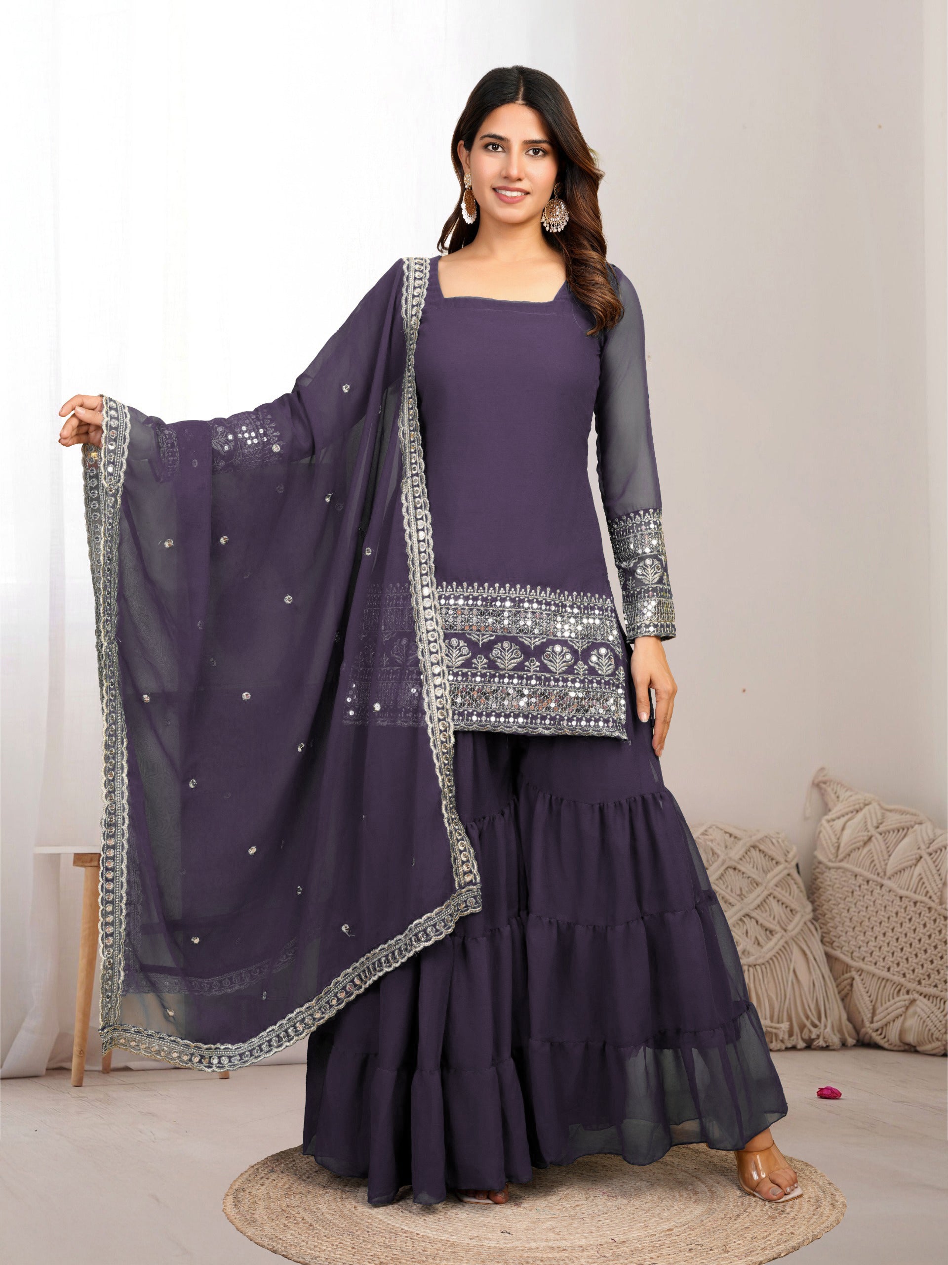 Woman wearing a purple traditional outfit with a matching dupatta on a neutral background