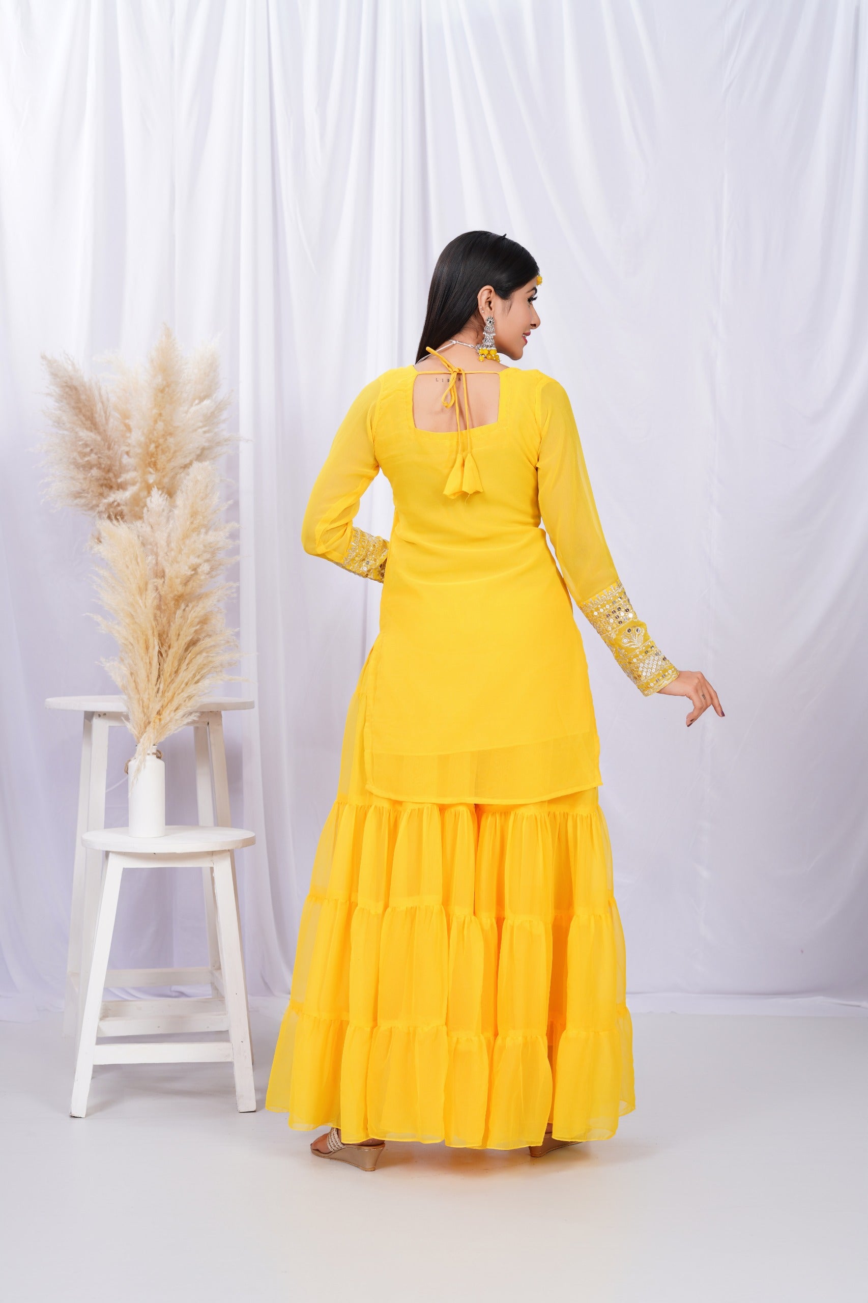 Woman wearing a yellow dress with a white background