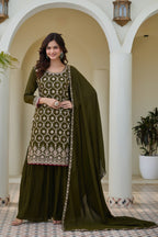 Woman in a green traditional outfit with embroidery in an elegant indoor setting