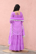 Mannequin wearing a purple outfit with a white border on a pink background