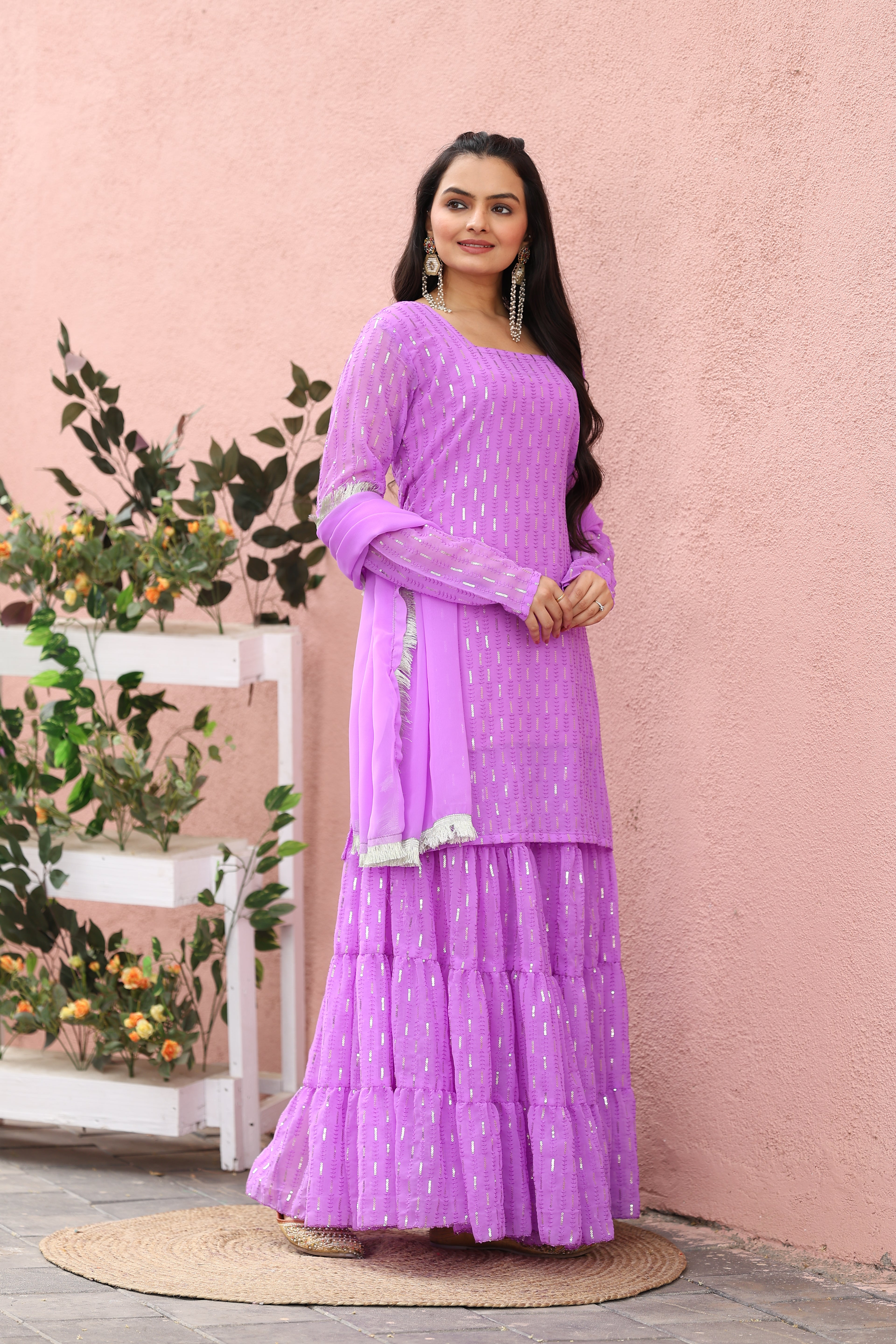 Woman wearing a purple traditional outfit with a pink background