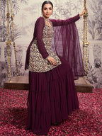 Woman in a traditional outfit with a purple top and sharara, standing on a swing with floral background.