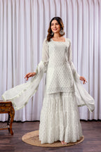 Woman wearing a white traditional outfit with a plain background